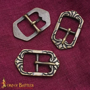Three decorative metal buckles on fabric